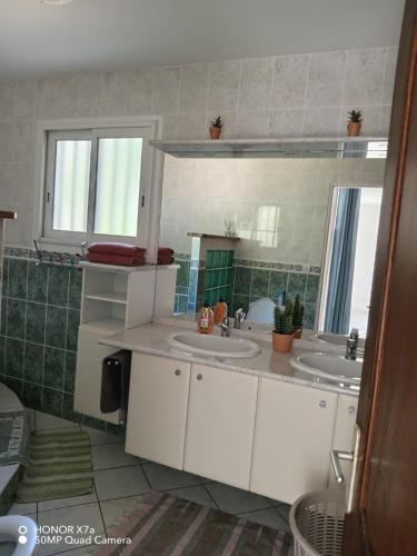 a bathroom with two sinks and a mirror at Leu doux bruit des vagues in Saint-Leu