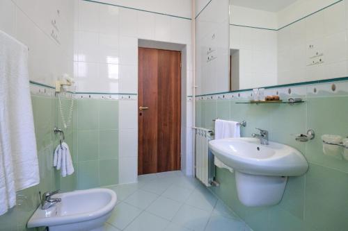 a bathroom with a sink and a toilet and a mirror at Hotel Roberto Sinaia in Sinaia