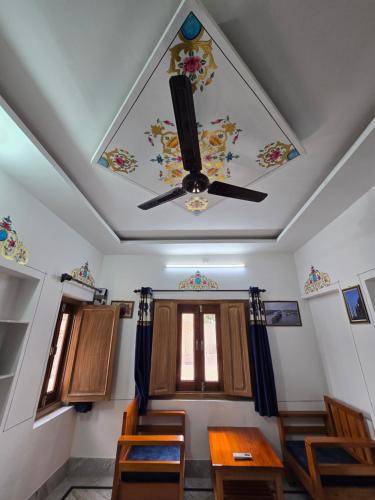 a dining room with a ceiling with a ceiling fan at little Princess Guest House in Bikaner