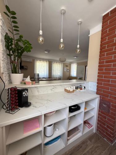 a kitchen with a white counter and a brick wall at Bogatu Vendégház in Bogács