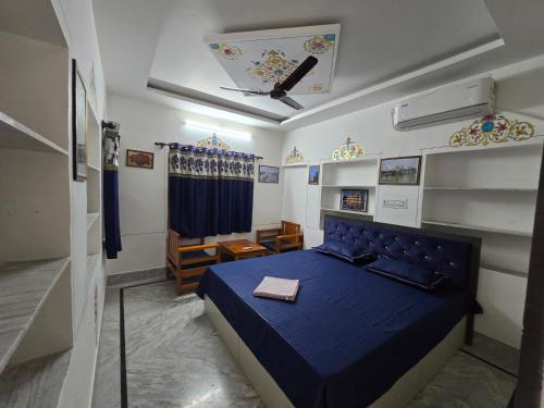 a bedroom with a blue bed in a room at little Princess Guest House in Bikaner