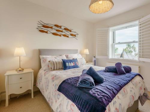 a bedroom with a bed with purple pillows on it at 2 Bed in Ventnor 90147 in Ventnor