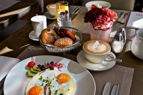a table with plates of breakfast food and a cup of coffee at Waldhotel Stuttgart in Stuttgart