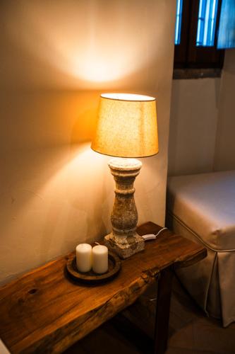 a lamp on a wooden table with two candles at Podere Dell'Arco Country Charme in Viterbo