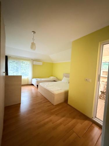 a bedroom with two beds and a wooden floor at Konstantin House in Sarpi