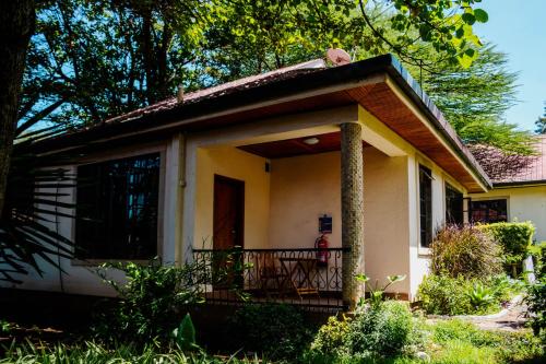 a small house with a porch and a balcony at Falcon Heights Hotel in Nanyuki