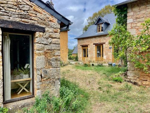 an old stone house with a window in a yard at Maison Arc-en-Ciel pour 1 à 6 personnes in Chartrier-Ferrière