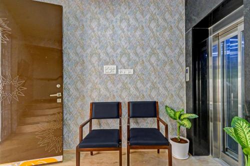 two chairs in a room with a wall at Super Hotel O SRI NIRVANA PLAZA in Gachibowli