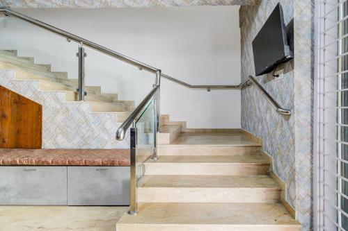 a set of stairs with a tv on the wall at Super Hotel O SRI NIRVANA PLAZA in Gachibowli