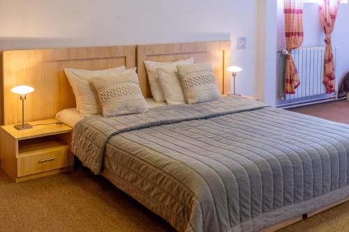 a bedroom with a large bed with two lamps at Hotel Roberto Sinaia in Sinaia