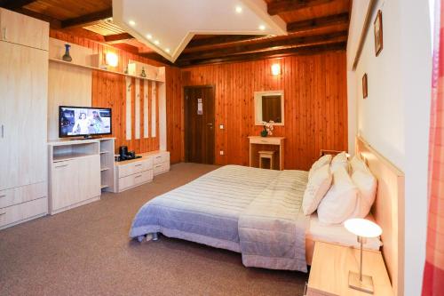 a bedroom with a bed and a flat screen tv at Hotel Roberto Sinaia in Sinaia