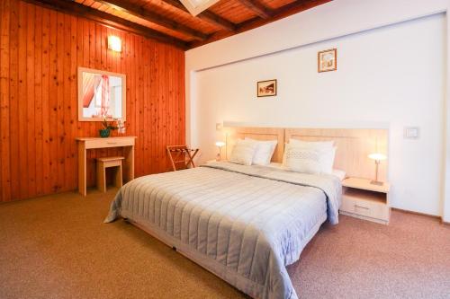 a bedroom with a large bed and a desk at Hotel Roberto Sinaia in Sinaia