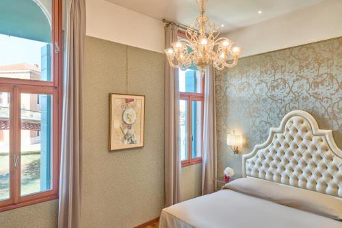 a bedroom with a bed and a chandelier at Hotel Santa Chiara in Venice