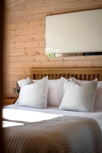 a bedroom with a bed with white pillows at Kingfisher Lodge Riverdale in West Tanfield