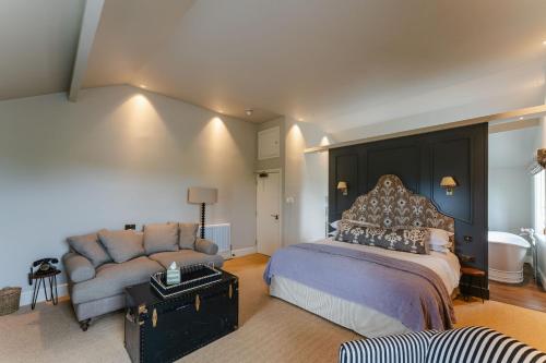 a large bedroom with a bed and a couch at The 3 Acres Inn & Restaurant in Huddersfield