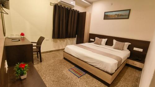 a hotel room with a bed and a desk and a table at Hotel Udaipur Stay at Prime Location in Udaipur