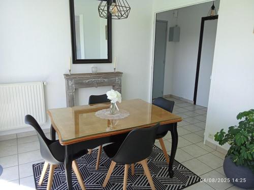 a dining room table with chairs and a vase of flowers at T2 - Terrasse avec vue imprenable - Secteur gare in Poitiers