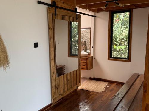 a bathroom with a wooden door and a mirror at Sweta Takawiri island Shamba house in Takawiri Island