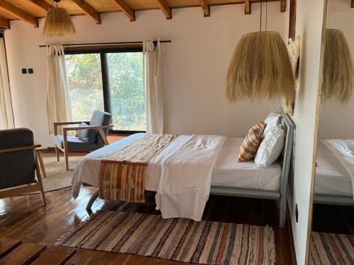 a bedroom with a bed and a large window at Sweta Takawiri island Shamba house in Takawiri Island