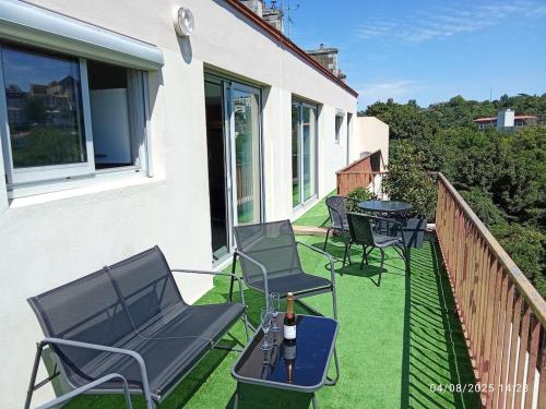 a patio with chairs and tables on a balcony at T2 - Terrasse avec vue imprenable - Secteur gare in Poitiers
