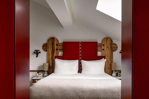 a bedroom with a large bed with a red headboard at Experimental Chalet Val d'Isère in Val dʼIsère