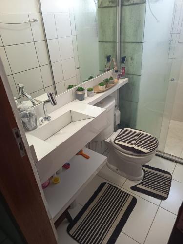 a bathroom with a sink and a toilet and a mirror at ApartamentoA306 in Ananindeua