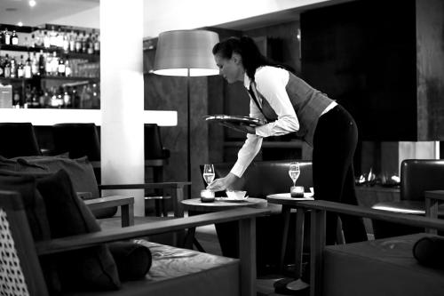 a woman standing at a table with a plate of food at Waldhotel Stuttgart in Stuttgart