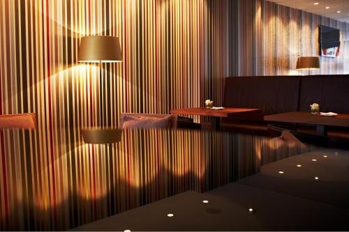 a room with a table and chairs and a striped wall at Waldhotel Stuttgart in Stuttgart