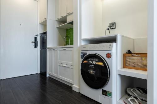 a washer and dryer in a kitchen with white cabinets at Capella Apartment Fireworks and Ocean View- Hillside Phu Quoc in Phu Quoc