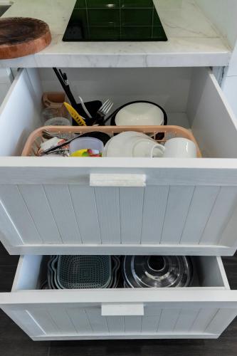 a kitchen drawer filled with dishes and utensils at Capella Apartment Fireworks and Ocean View- Hillside Phu Quoc in Phu Quoc