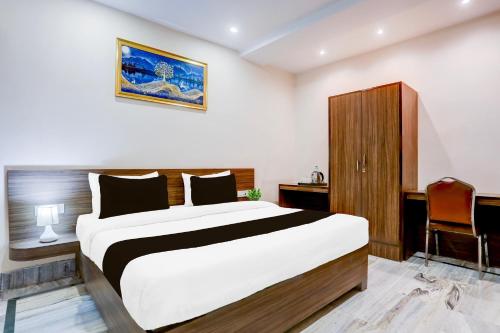 a bedroom with a large bed and a desk at Hotel O Ganga Niwas in Prayagraj