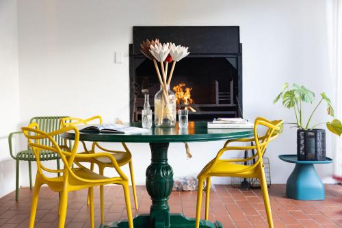 a dining room with a green table and yellow chairs at Stanford River Retreat in Stanford