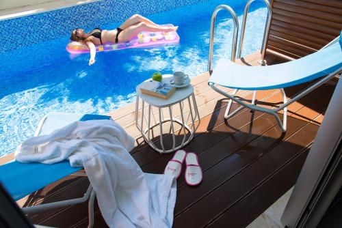 a woman laying on a raft in a swimming pool at Flora Garden Ephesus Kusadasi - All Inclusive in Davutlar