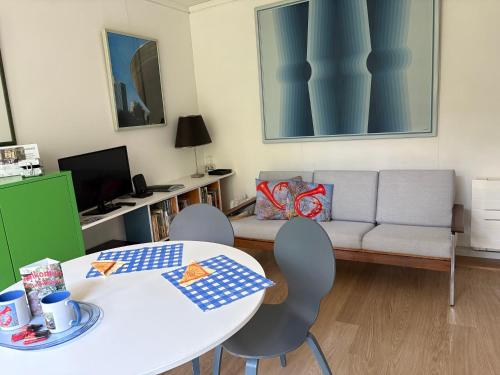 a living room with a couch and a table and chairs at Linden-Jachthoorn in Lubbeek