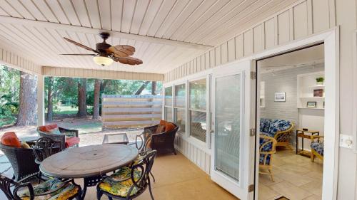 a screened in porch with a table and chairs at BEACHY SISTERS B Duplex in Jekyll Island
