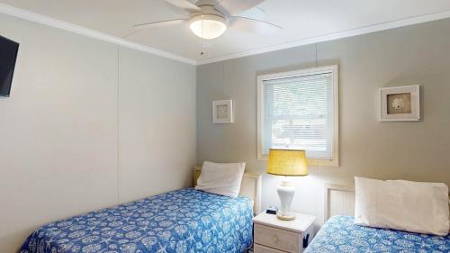 a bedroom with two beds and a ceiling fan at BEACHY SISTERS B Duplex in Jekyll Island