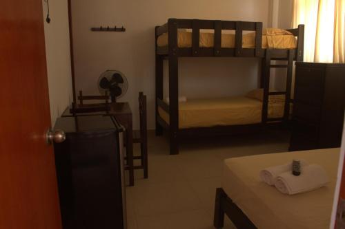 a room with two bunk beds and a table at Bungalows Rupay Wasi in Los Órganos