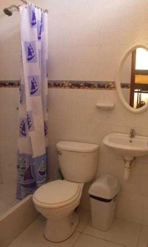 a bathroom with a toilet and a sink at Bungalows Rupay Wasi in Los Órganos
