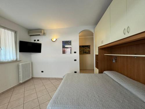 a bedroom with a bed and a tv on the wall at Alessio Camere in Bardolino