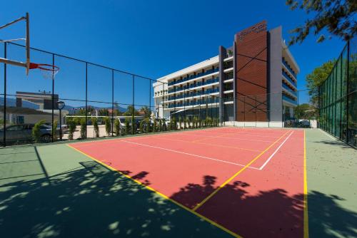 a tennis court in front of a building at Flora Garden Ephesus Kusadasi - All Inclusive in Davutlar