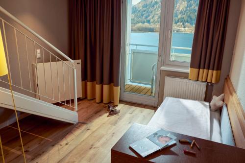 a bedroom with a large window and a bed with a table at ROBINSON Landskron in Landskron
