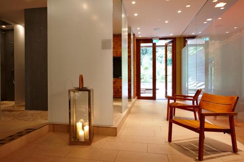a room with a chair and a glass case with candles at Waldhotel Stuttgart in Stuttgart
