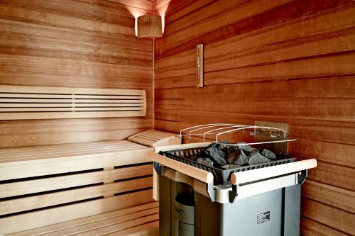 a sauna with a grill and wooden walls at Waldhotel Stuttgart in Stuttgart