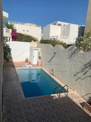 a swimming pool in the side of a building at Villa avec piscine au style Sibi Bou Saïd in Sousse