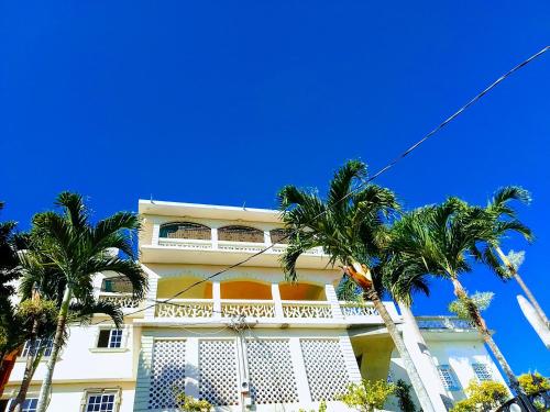 a white building with palm trees in front of it at Bayview Luxury Retreat 