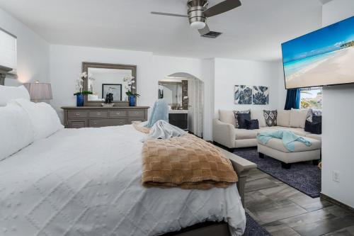 a bedroom with a large bed and a living room at Dream Tropical Oasis 10 mins Walking to the Beach in Marco Island