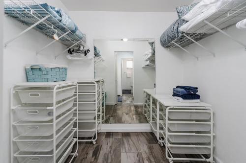 a room with white racks and a mirror at Dream Tropical Oasis 10 mins Walking to the Beach in Marco Island