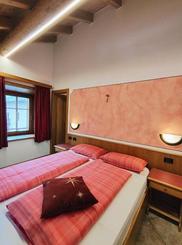 een slaapkamer met 2 bedden met rode kussens bij PiZABELA MANSARDE in Livigno