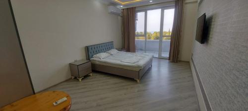 a small bedroom with a bed and a window at Astara Kaspi Apart 2-5 in Astara