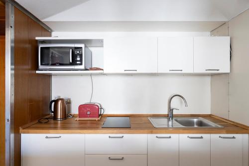 a kitchen with a sink and a microwave at Anzolo Palace - Rooms & Apartments in Venice